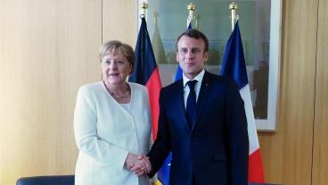 Den tyska förbundskanslern Angela Merkel och den franske presidenten Emmanuel Macron skakar hand pre-corona. Arkivbild.