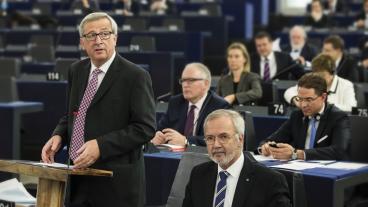 Jean-Claude Juncker till vänster, EIB-chefen Werner Hoyer till höger och tillväxtkommissionär Jyrki Katainen knappandes på mobiltelefon under onsdagens presentation i EU-parlamentet,