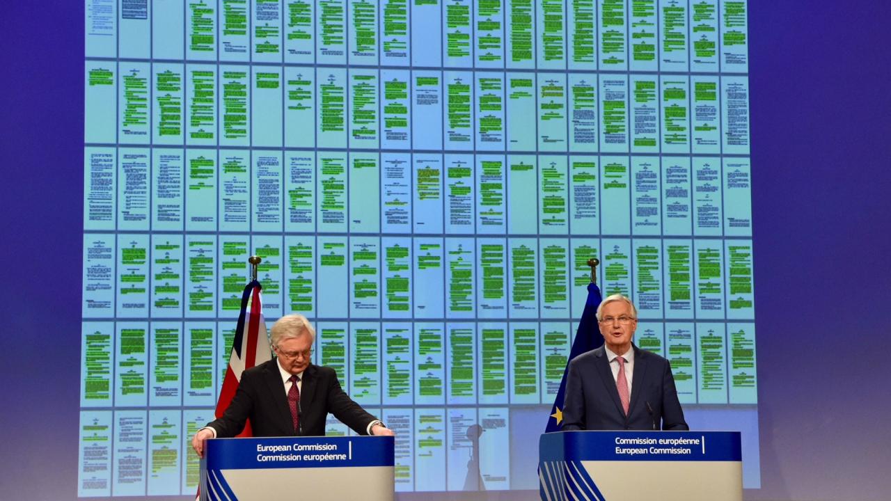  EU:s och Storbritanniens chefsförhandlare, Michel Barnier och David Davis, framför de 129 färgkodade sidorna i utträdesavtalet.